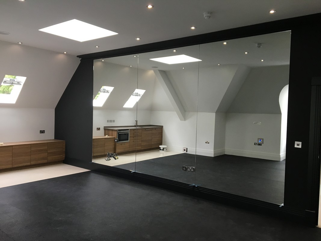 Frameless glass wall dividing loft conversion in New Cross Gate